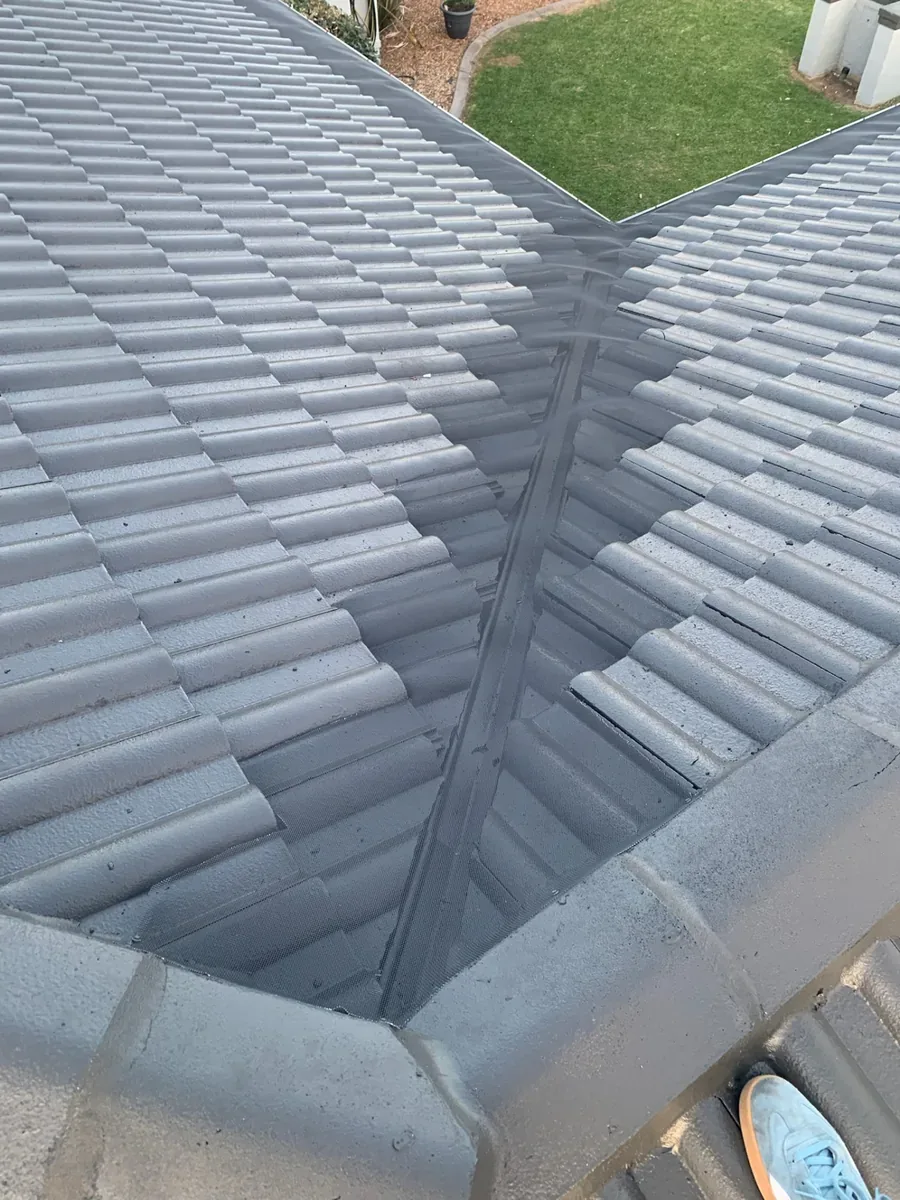 Metal ember mesh fitted across a tiled roof valley where two roof planes meet