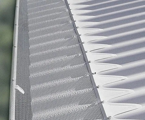 Metal ember mesh installed on a corrugated roof with bushland nearby